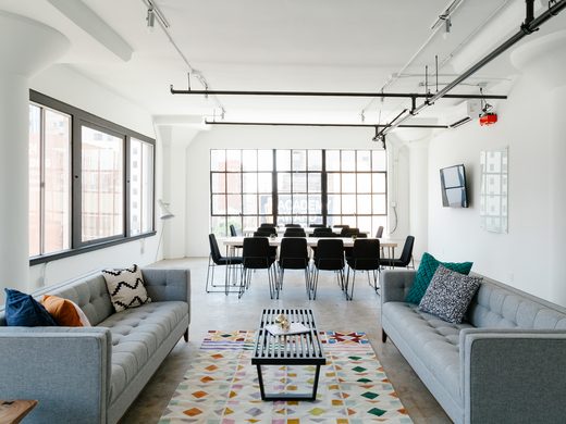 Loft lounge with grey sofas and tall windows