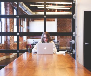 Woman working at the end of a long wooden table