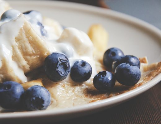 Blueberries next to a white cream dessert
