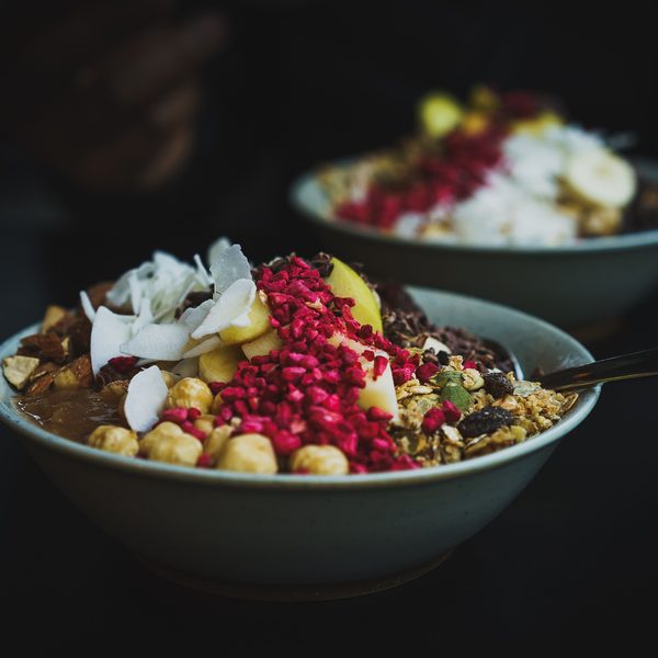 Breakfast bowl with fruit and granola on a dark table