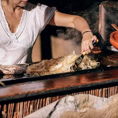 Cook working over a busy grill