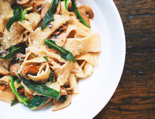 Ribbon pasta with green beans and herbs on a white plate