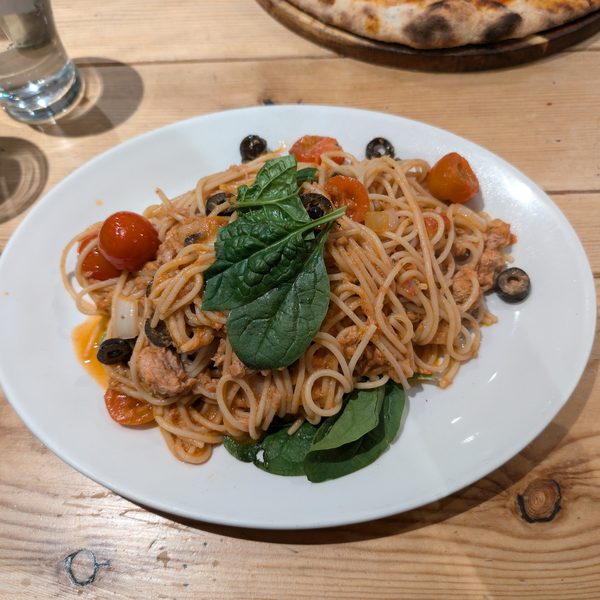 Plate of spaghetti with basil on a wooden table