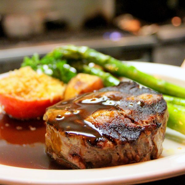 Grilled steak with asparagus on a white plate