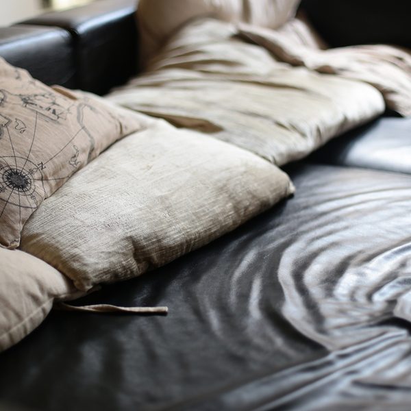 Cream linen cushions resting on a dark leather sofa
