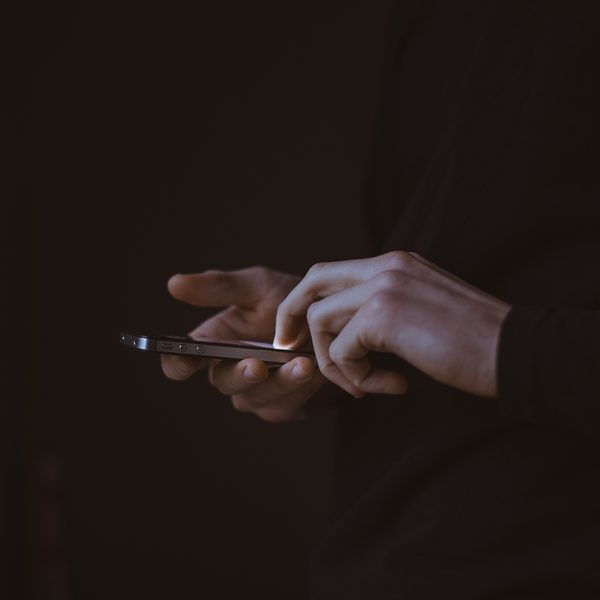 Hands holding a phone in a dark room