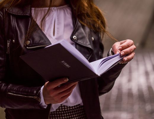 Person reading a book by a window