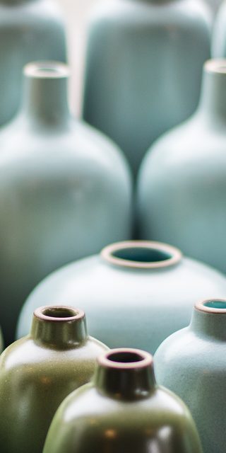 Pale blue glazed bottle vases in soft light