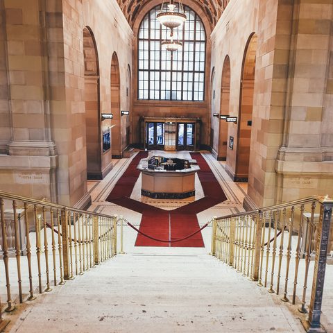 Grand stone entrance hall with brass stair rails