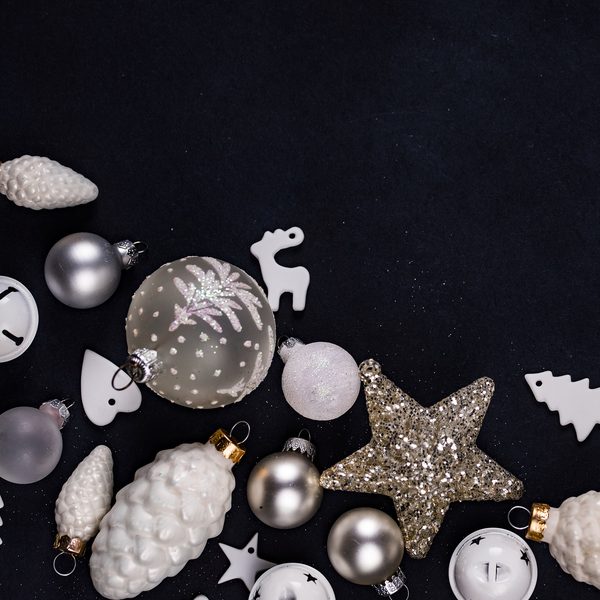 White and silver glass ornaments and a glitter star on black