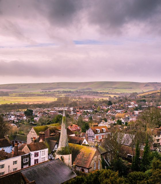 Church spire above the rooftops of a small town at dusk