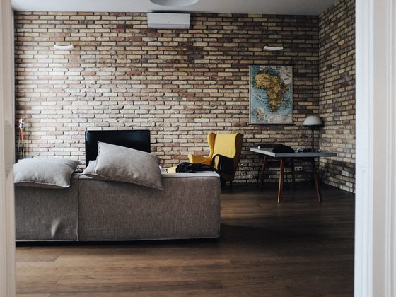 Apartment living room with a brick wall and a grey sofa