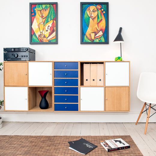 Open shelving with blue and wooden boxes beside a white chair