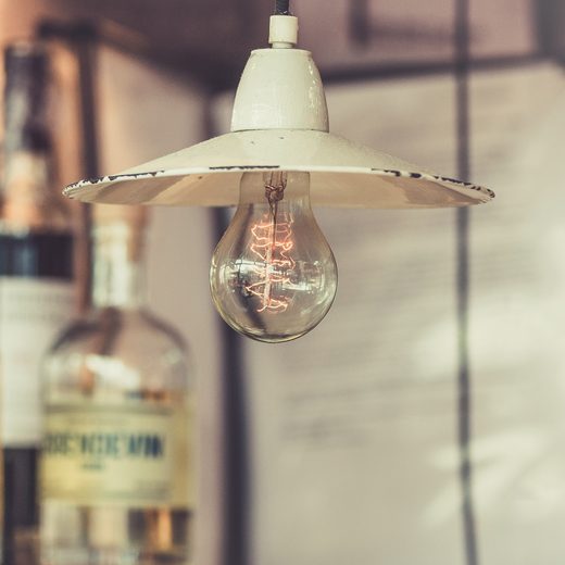 Bare light bulb in a white metal shade