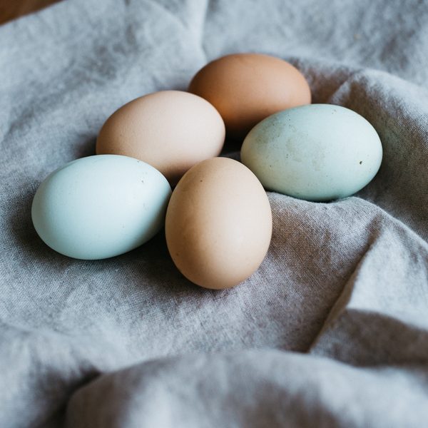 Pale blue and brown eggs resting on a gray linen cloth