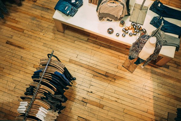 Clothes rack and display table on a wood shop floor seen from above