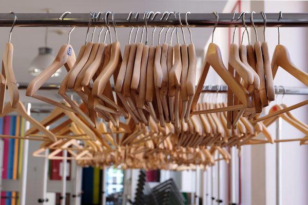 Wooden hangers crowded on a metal shop rail