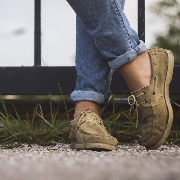 Tan suede deck shoes worn with rolled blue jeans