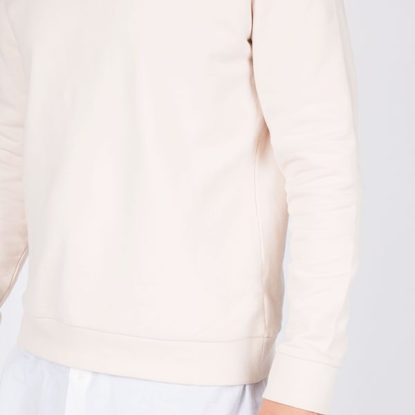Cream cotton sweatshirt worn over a white shirt