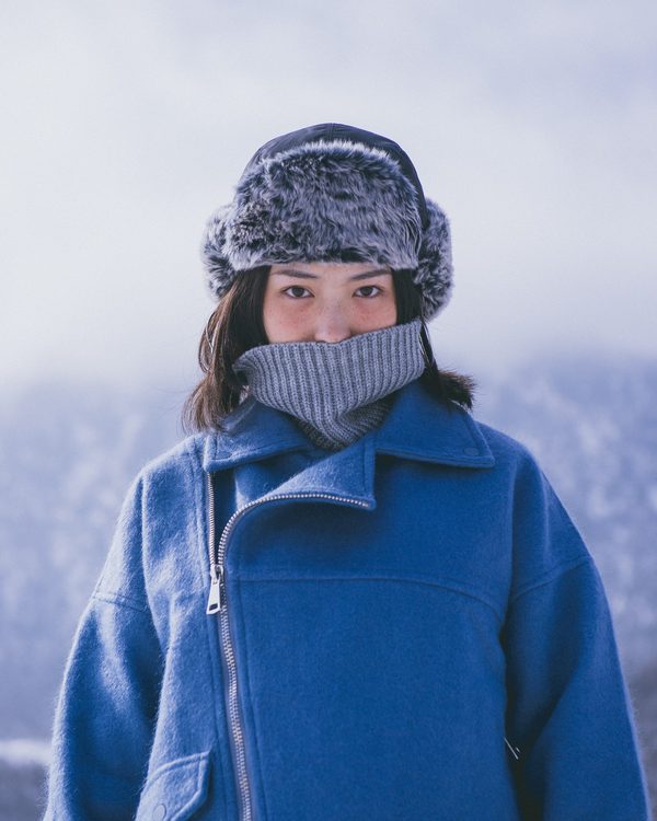 A woman in a cobalt blue wool coat and fur hat in the snow