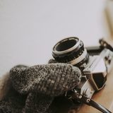 Grey wool scarf beside a vintage camera