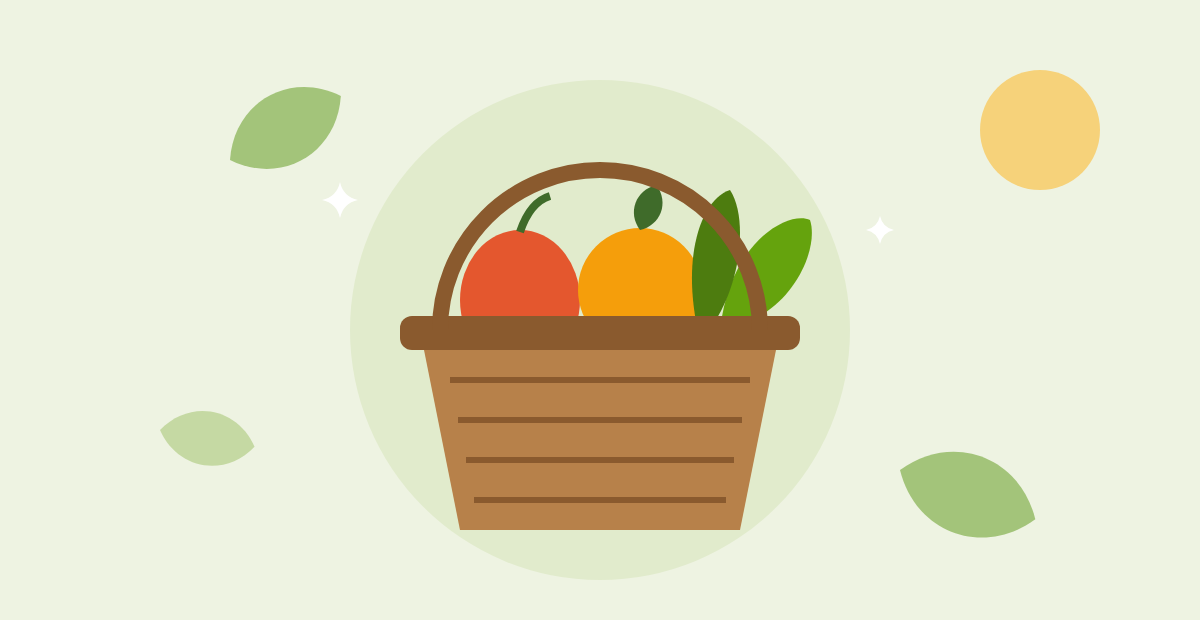 Woven basket with an apple, an orange and fresh greens