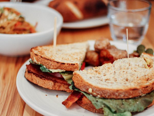 Toasted sandwich and side dishes on a wooden table