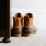 Pair of brown and tan boots on a white rug