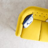 Mustard yellow armchair with a blue patterned cushion