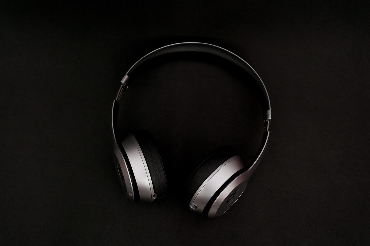 Silver and black over-ear headphones lying on a black surface