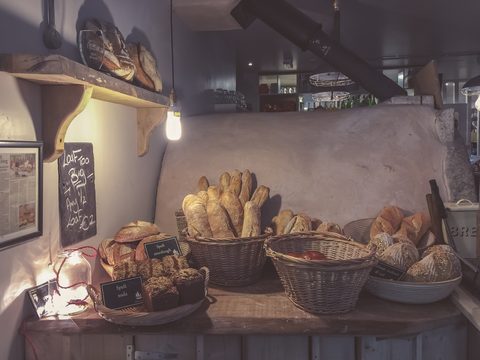 Baskets of rustic bread on a wooden shop counter