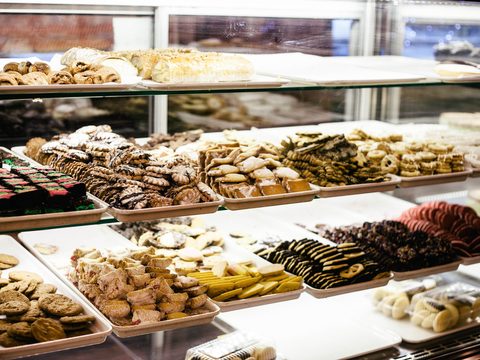Glass case with trays of pastries and small cakes