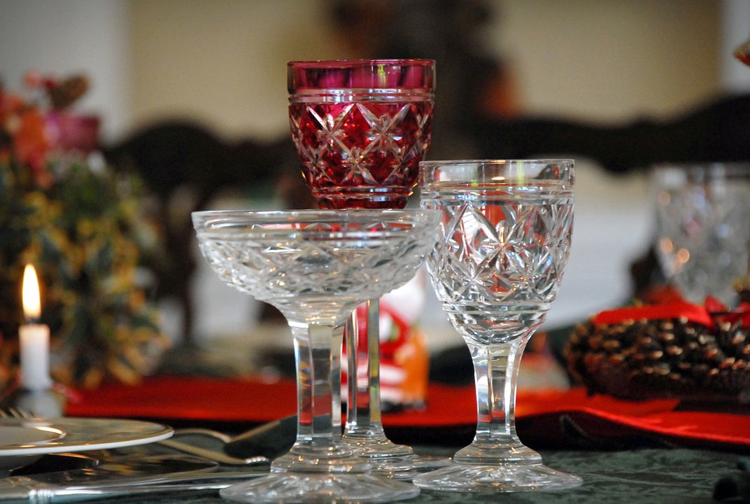 Crystal coupes and a red glass on a festive table with candlelight