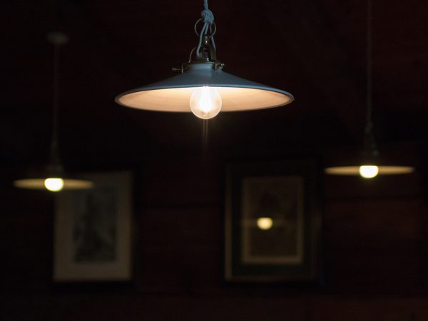 Warm pendant lamps glowing over a dark wood paneled lounge