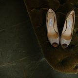Pair of cream satin heels on a dark velvet chair