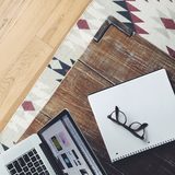 Glasses resting on an open notebook on a wooden desk