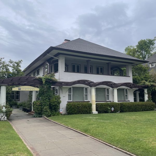 A two storey craftsman house with a wide porch and green lawn