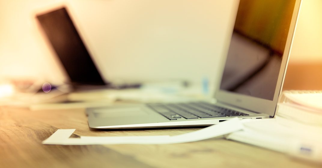 Open laptop on a wooden desk in warm light