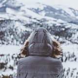 Person in a grey hooded winter jacket seen from behind