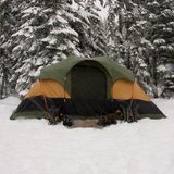 Green two person tent pitched in fresh snow