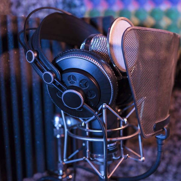 Studio headphones hanging next to a microphone