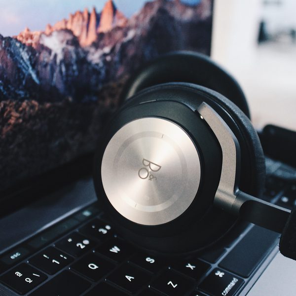 Silver headphones resting on a laptop keyboard