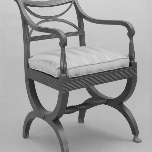 Dark wood armchair with curved legs and a pale seat cushion