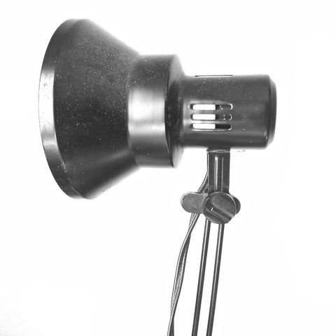 Black metal desk lamp with a round shade on a white background