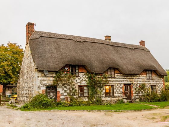 Thatched stone cottage with flowers by the front door