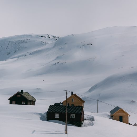 Small wooden huts on a white snowy hillside