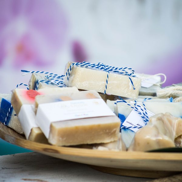 Handmade bars of soap tied with string on a wooden plate