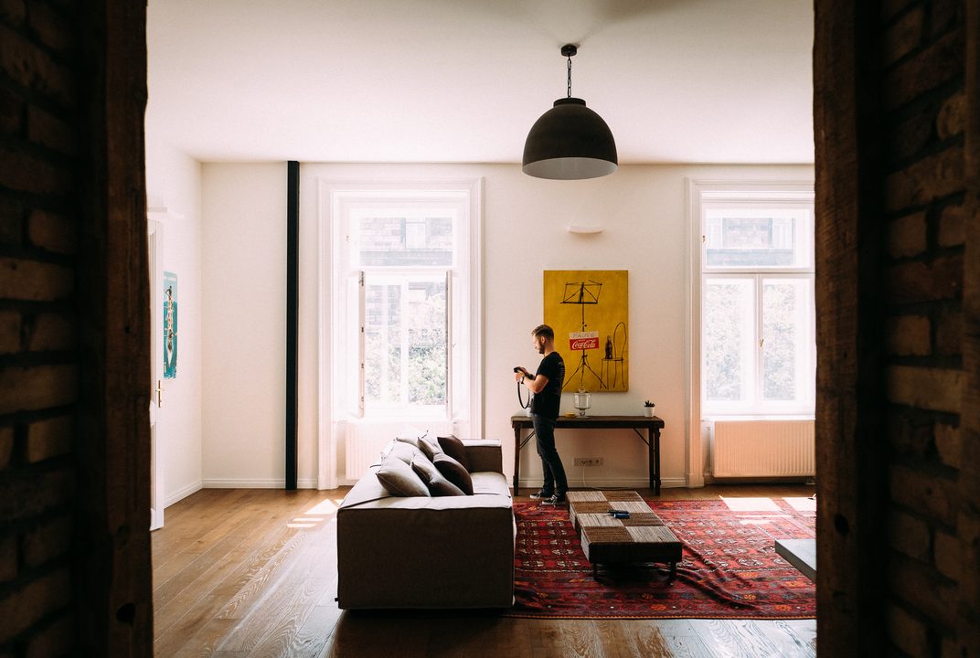 Bright apartment living room with a sofa, rug and tall windows