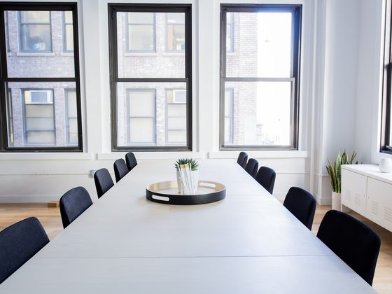 Bright meeting room with a long white table and black chairs