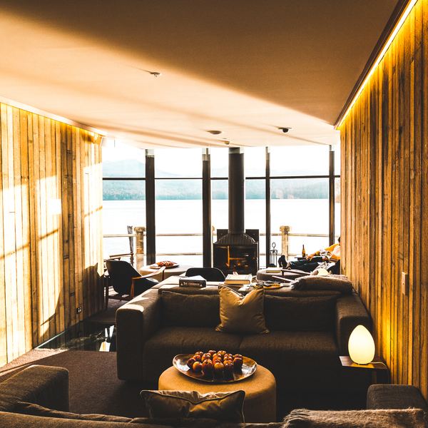 A warm wood panelled suite lounge with sofas facing the water